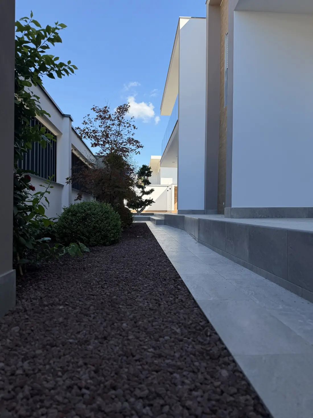 L'ingresso della villa finita, con la pavimentazione in gres e le aiuole